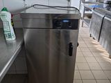 une armoire en acier inoxydable au milieu d'une cuisine dotée de nombreux plans de travail