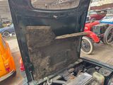 an old car with a broken engine in the back of it