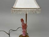 lampe en forme de figurine rose avec un abat-jour blanc et un pied doré