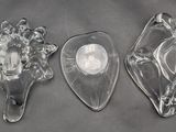 three clear glass wall sconces sitting on top of a gray surface