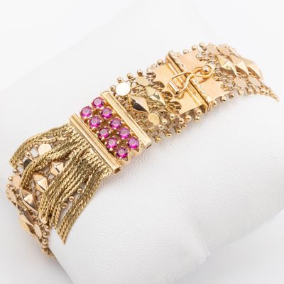 a close up of a gold bracelet with pink stones on it