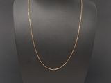 a gold chain necklace on a mannequin neck
