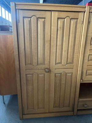 une image représentant une armoire en bois avec des tiroirs et une porte