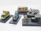four model cars and a van on display on a table