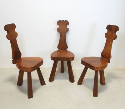 three wooden chairs sitting next to each other in a room