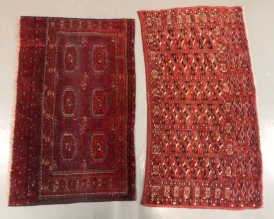 two pieces of red and black rugs on a white surface