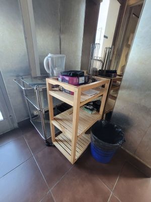 a kitchen with a wooden cart and a blue bucket on the floor