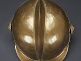 an antique brass helmet on a black background