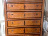 a wooden chest of drawers with a lamp on top of it
