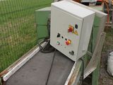 a machine that is sitting on the ground next to a fence