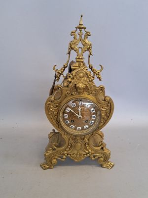 une horloge en or posée sur une table blanche