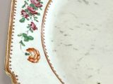 a white plate with a gold border and flowers on it