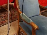 a blue chair in a room with a red table and red table cloth