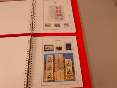 a red book with two pages of stamps on top of it