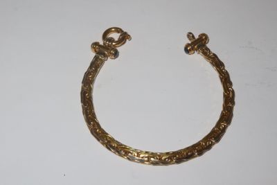 an image of a gold bracelet on a white surface