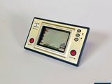 une petite Game Boy posée sur une table blanche