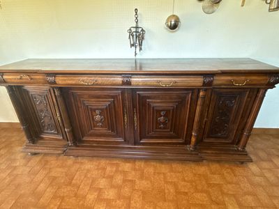 a wooden cabinet with a marble top on a hard wood floor