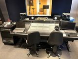 an image of a recording studio with a desk and monitors