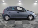 a picture of a small blue car parked in a garage