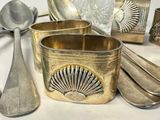 a lot of silver spoons and other silverware on a table