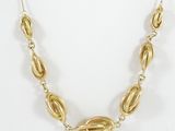 a close up of a gold necklace on a white background