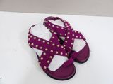 a close up of a pair of purple sandals on a white surface