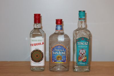 trois bouteilles d'alcool posées les unes à côté des autres sur une table