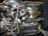 a box full of silver spoons and forks in it