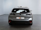 the rear end of a silver car in a white room