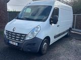 La camionnette blanche est garée sur le parking, à côté d'un bâtiment en briques.