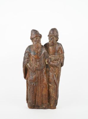 une vieille figurine en bois représentant deux hommes debout l'un à côté de l'autre