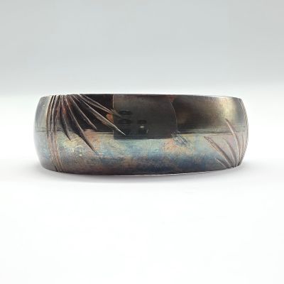 un gros plan d'un bracelet en métal orné d'un motif