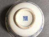 a white and blue vase with a blue design on it
