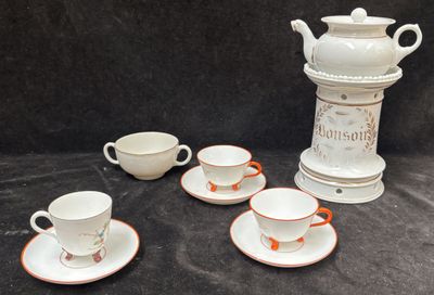 plusieurs tasses et soucoupes posées sur une table, avec un vase en arrière-plan