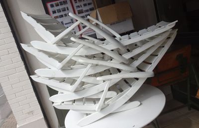 une grande pile de chaises blanches posées sur une table