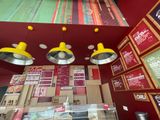 three yellow lamps hanging from the ceiling of a restaurant