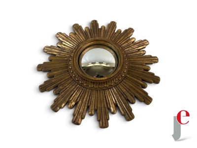 a gold sunburst mirror on a white wall