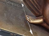 a bronze statue of a cat sitting on top of a book
