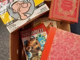 trois livres dans une boîte posée par terre, les uns à côté des autres