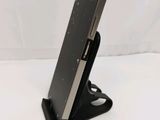 a close up of a cell phone on a stand on a white surface