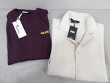 two men ' s sweaters and a t - shirt on a couch