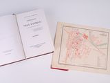 an open book sitting on top of a table next to a map