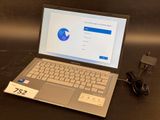 a laptop computer sitting on a table with a charger on it