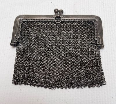 a black metal purse with chain around it on a white surface
