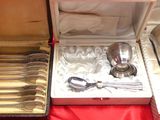 des couverts dans un coffret en argent posé sur une nappe rouge