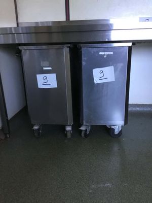 two trash cans sitting next to each other on the floor