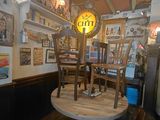 a table and chairs in a room with pictures on the wall