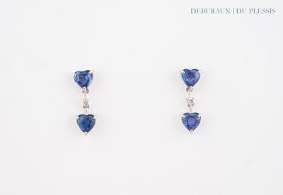 une paire de boucles d'oreilles en saphir bleu et diamants sur fond blanc