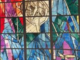 a woman standing in front of a stained glass window