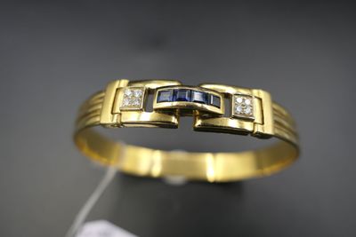 un gros plan d'une bague en or jaune sertie de diamants bleus et blancs